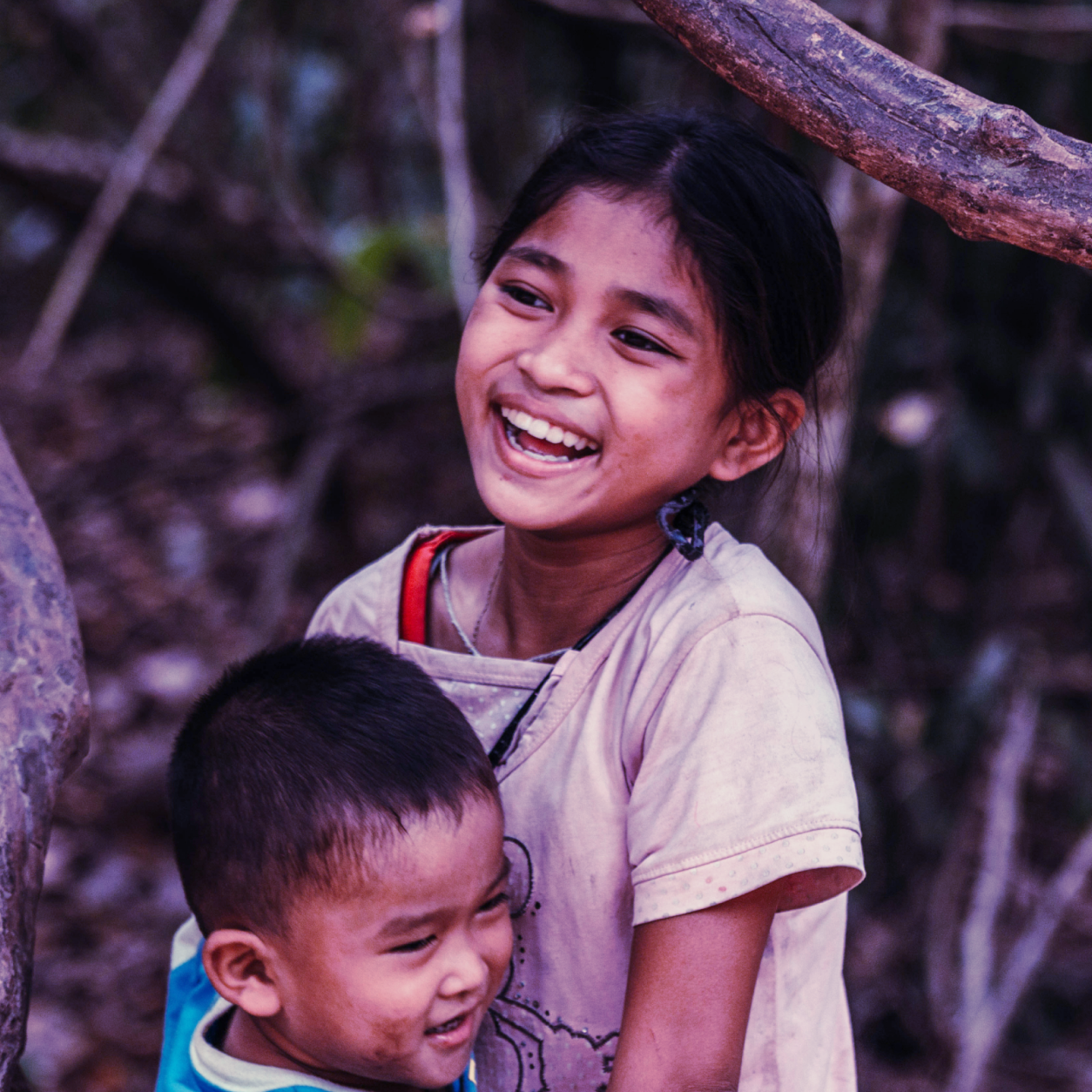 Niños de comunidades vulnerables sonriendo gracias al acceso a la telemedicina solidaria y atención médica global.